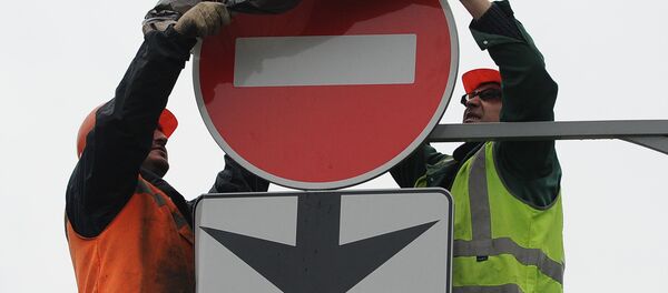Дорожные рабочие завешивают знак, запрещающий выезд. Архивное фото - Sputnik Кыргызстан