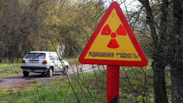 Автомобиль на фоне дорожного знака радиации. Архивное фото - Sputnik Кыргызстан