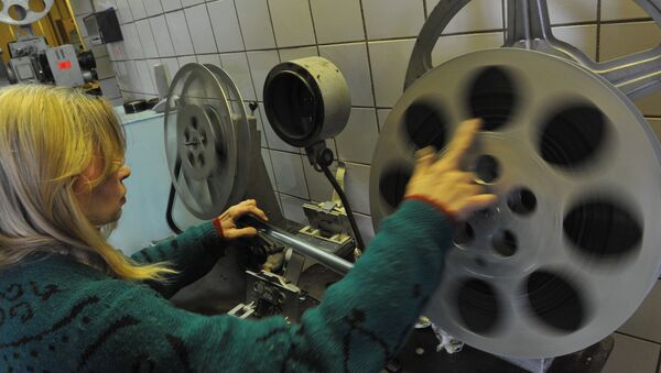 Сотрудница кинотеатра заправляет бабину в кинопроектор. Архивное фото - Sputnik Кыргызстан