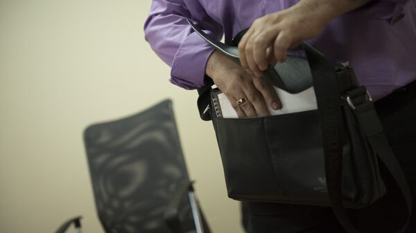 Мужчина кладет бумаги в портфель. - Sputnik Кыргызстан