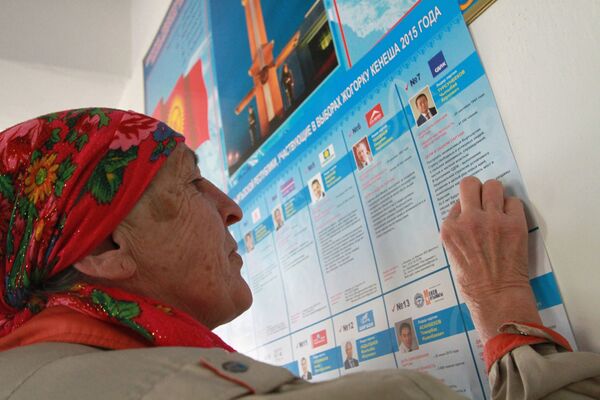 Женщина у предвыборного списка кандидатов на избирательном участке в селе Байтик. Архивное фото - Sputnik Кыргызстан