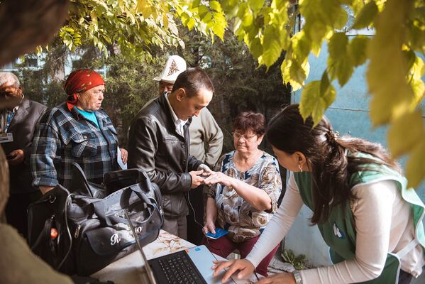 Избиратель проходит проверку биометрических данных для досрочного голосования на выборах в Жогорку Кенеш - Sputnik Кыргызстан