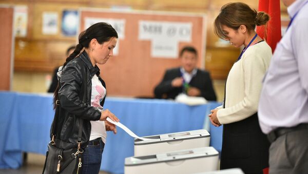 Избиратель отпускает бюллетень в урну на избирательном участке. Архивное фото - Sputnik Кыргызстан