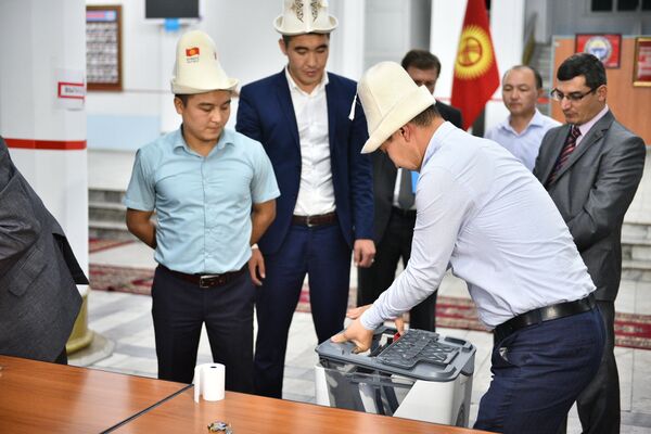 Члены комиссии снимают крышку урны для подсчета голосования. Архивное фото - Sputnik Кыргызстан