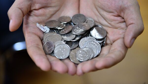 Национальные монеты в руках человека. Архивное фото - Sputnik Кыргызстан
