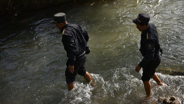 Сотрудники МВД переходят реку в Жилмассиве Энесай - Sputnik Кыргызстан