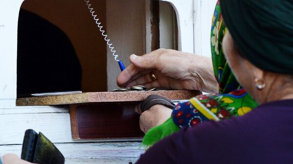 Пожилая женщина получает пенсию. Архивное фото - Sputnik Кыргызстан