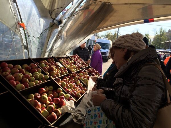Житель Москвы покупает яблоки на ярмарке. - Sputnik Кыргызстан