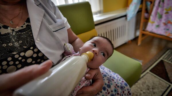 Женщина кормит ребенка. Архивное фото - Sputnik Кыргызстан