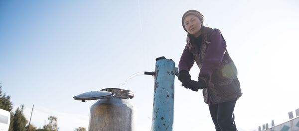 Женщина качает питьевую воду с колонки. Архивное фото - Sputnik Кыргызстан