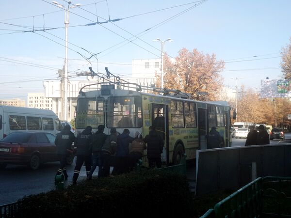 Сотрудники ДПС и жители города толкают троллейбус. - Sputnik Кыргызстан
