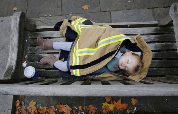 Малыш спит на скамейке в центре Лондона во время акции протеста пожарных. - Sputnik Кыргызстан