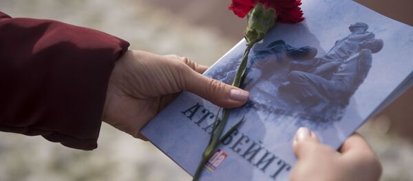 Женщина держит брошюру «Ата-Бейит» и гвоздику. Архивное фото - Sputnik Кыргызстан