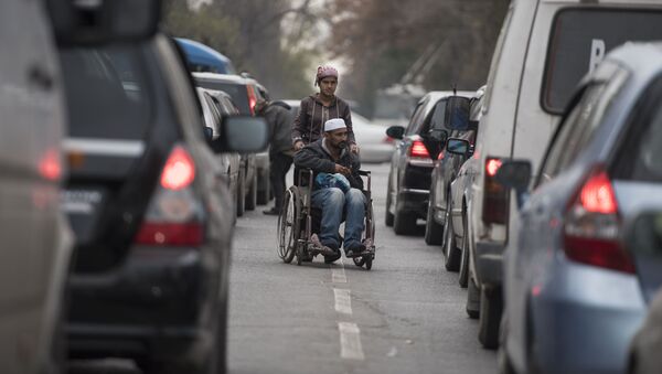 Мужчина в инвалидной коляске и женщина которые попрошайничают на одном из улиц Бишкека. - Sputnik Кыргызстан
