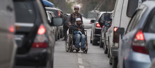 Мужчина в инвалидной коляске и женщина которые попрошайничают на одном из улиц Бишкека. - Sputnik Кыргызстан