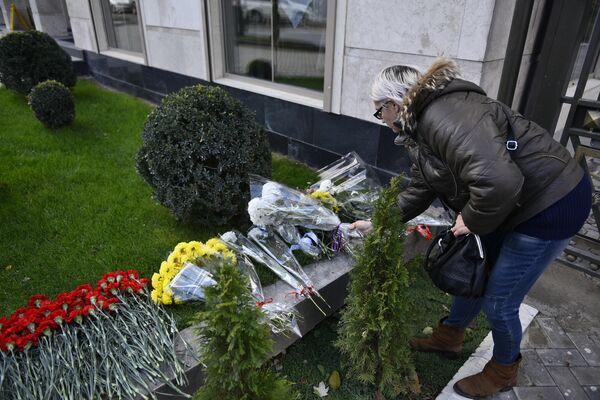 Кыргызстанцы не остаются в стороне. К зданию посольства в Бишкеке они приносят цветы и ставят свечи. - Sputnik Кыргызстан