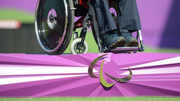 Спортсмен в инвалидной коляске и эмблема Паралимпиады. Архивное фото - Sputnik Кыргызстан