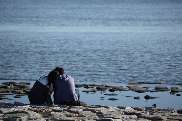 Парень и девушка сидят на берегу моря. Архивное фото - Sputnik Кыргызстан