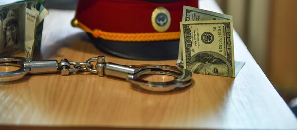 Милицейская фуражка, наручники и сто долларовая купюра на столе. Архивное фото - Sputnik Кыргызстан