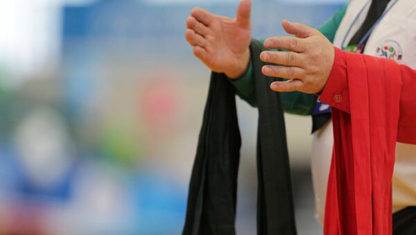 Пояса разного цвета на руках судьи перед поединком на чемпионате по борьбе на поясах. Архивное фото - Sputnik Кыргызстан