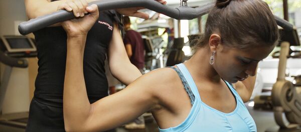Девушка во время занятия с тренером в тренажерном зале.  Архивное фото - Sputnik Кыргызстан