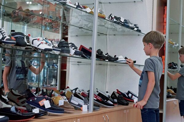 Мальчик выбирает обувь в магазине. Архивное фото - Sputnik Кыргызстан