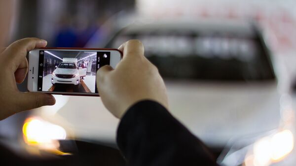 Мужчина фотографирует автомобиль на телефон. Архивное фото - Sputnik Кыргызстан