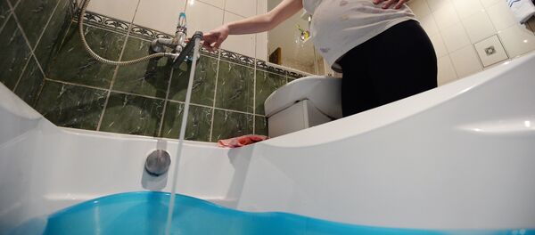 Женщина набирает воду в ванной комнате. Архивное фото Женщина набирает воду в ванной комнате. Архивное фото - Sputnik Кыргызстан