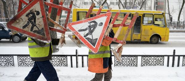 Работники коммунальных служб несут ограждения со знаком Ремонтные работы. Архивное фото Работники коммунальных служб несут ограждения со знаком Ремонтные работы. Архивное фото - Sputnik Кыргызстан