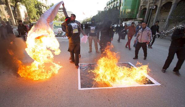 Демонстранты на улицах Саудовской Аравии сжигают флаги - Sputnik Кыргызстан