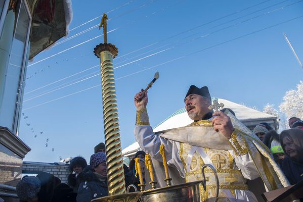 Священнослужитель с кропилом проводит обряд освящения - Sputnik Кыргызстан