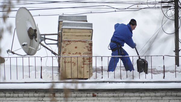 Сотрудник коммунальной службы чистит крышу от снега. Архивное фото - Sputnik Кыргызстан