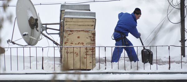 Сотрудник коммунальной службы чистит крышу от снега. Архивное фото - Sputnik Кыргызстан