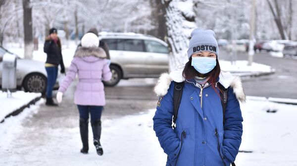 Девушка в медицинской маске идет по улице Бишкека. Архивное фото - Sputnik Кыргызстан