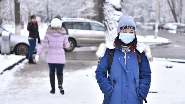 Девушка в медицинской маске идет по улице Бишкека. Архивное фото - Sputnik Кыргызстан