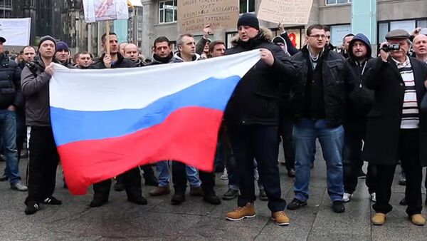 Кельнцы с флагами РФ вышли на митинг из-за инцидента с девочкой в Берлине - Sputnik Кыргызстан
