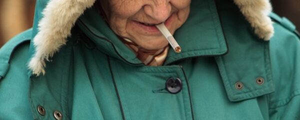 Пенсионерка прикуривает сигарету. Архивное фото - Sputnik Кыргызстан