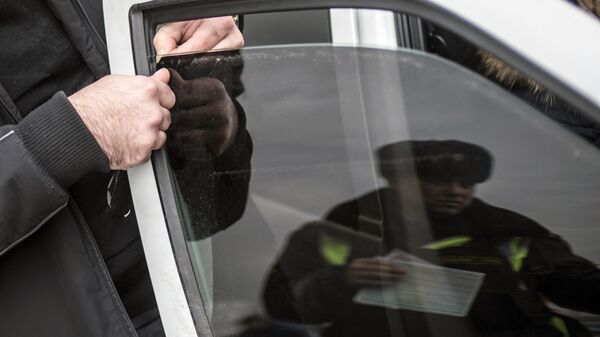 Автовладелец снимает тонировочную пленку со стекла своего автомобиля. Архивное фото - Sputnik Кыргызстан