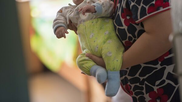 Женщина с новорожденным ребенком в руках. Архивное фото - Sputnik Кыргызстан
