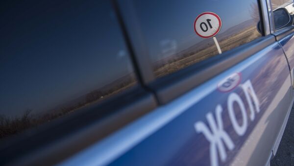 Отражение в машине дорожно-патрульной службы знака ограничения максимальной скорости. Архивное фото - Sputnik Кыргызстан