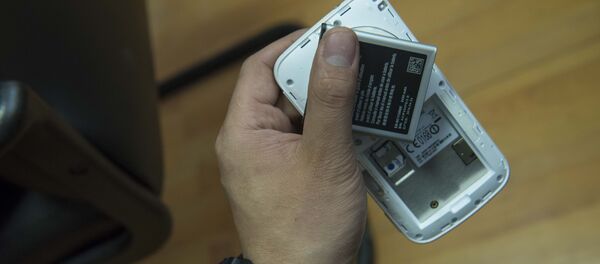 Мужчина держит телефон с батарейкой. Архивное фото Мужчина держит телефон с батарейкой. Архивное фото - Sputnik Кыргызстан