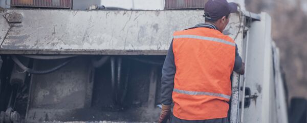 Тазалык ишканасынын кызматкери таштанды чыгаруу учурунда. Архив - Sputnik Кыргызстан