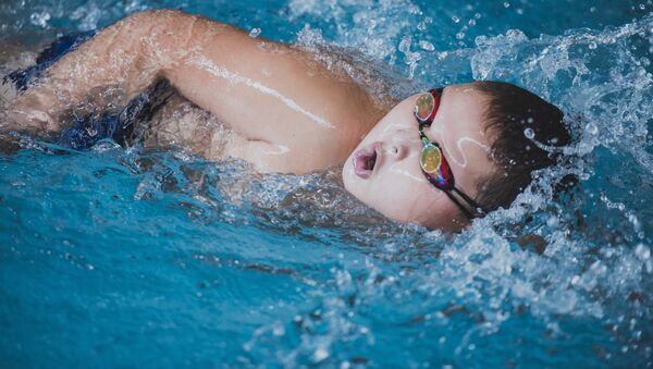 Мальчик плавает в бассейне во время соревнований - Sputnik Кыргызстан
