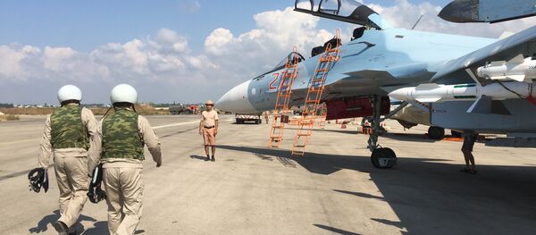 Российские летчики готовятся к посадке в истребитель Су-30 перед вылетом с аэродрома Хмеймим в Сирии. Архивное фото - Sputnik Кыргызстан