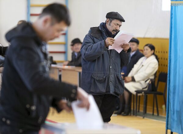 Мужчина на избирательном участке во время парламентских выборов в казахстанском селе Торетам - Sputnik Кыргызстан