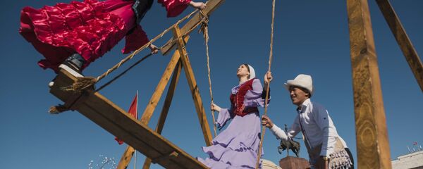 Молодые люди играют на качелях во время празднования Нооруз в Бишкеке. Архивное фото - Sputnik Кыргызстан