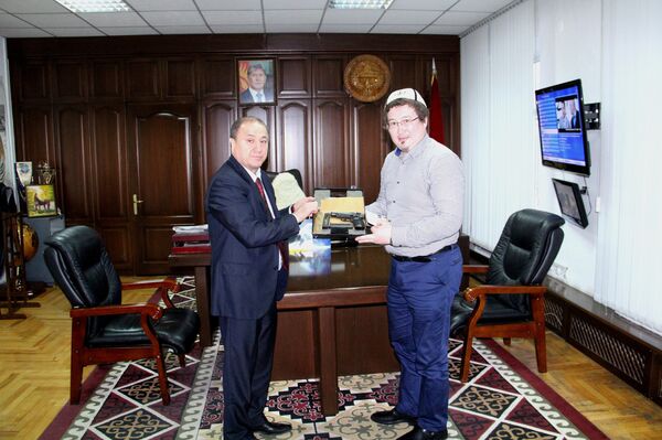 Министр внутренних дел КР Мелис Турганбаев вручает пистолет Кадыру Маликову - Sputnik Кыргызстан
