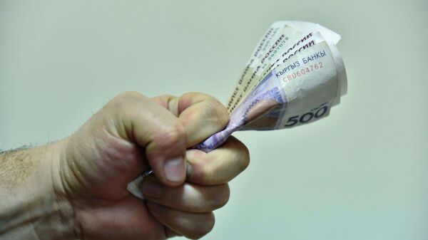 Мужчина в кулаке держит деньги. Архивное фото - Sputnik Кыргызстан