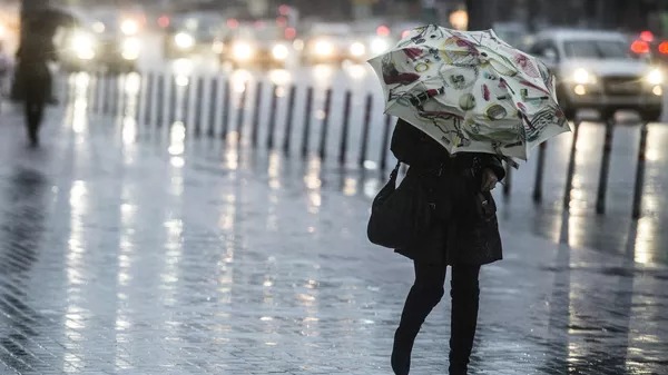 Девушка с зонтом идет по улице во время сильного дождя. Архивное фото  - Sputnik Кыргызстан