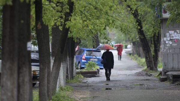 Женщина идет под зонтом. Архивное фото - Sputnik Кыргызстан